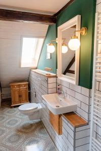a bathroom with a sink and a toilet and a mirror at Loft auf Fehmarn 800m zum Strand in Fehmarn