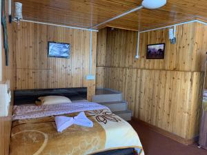 a bedroom with a bed in a wooden wall at Ridge View Chalet Homestay in Darjeeling