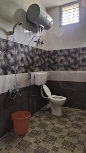 a bathroom with a toilet and a camera on the wall at Wanderers Stays in Mangalore