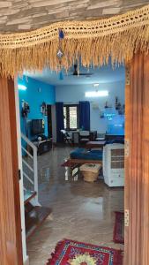 un salon aux murs bleus et une chambre avec une table dans l'établissement Wanderers Stays, à Mangalore