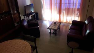 a living room with a couch and a table and a tv at Le Casone in Ajaccio