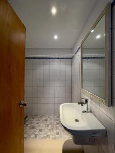 Residence Royal - Deluxe في Hammamet Sud: حمام مع حوض ومرآة