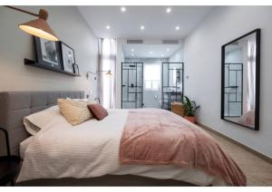 een slaapkamer met een groot bed en een grote spiegel bij Your Luxury Malta Home! in San Ġwann