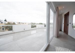 een grote witte kamer met grote ramen en een balkon bij Your Luxury Malta Home! in San Ġwann
