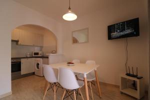 a kitchen and dining room with a table and chairs at Apartamento 2 habitaciones-wifi gratis in Son Bou