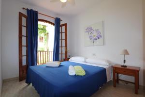 a bedroom with a blue bed with two towels on it at Apartamento 2 habitaciones-wifi gratis in Son Bou
