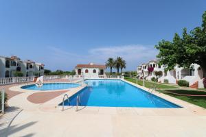 a large swimming pool in a yard with houses at Apartamento 2 habitaciones-wifi gratis in Son Bou