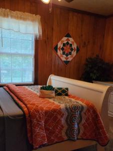 a bedroom with a bed with a quilt on it at Cozy bungalow near Hanging Rock and Chateau Vie. 