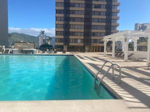 a swimming pool with a gazebo next to a building at Hawaiian monarch cozy studio in Honolulu