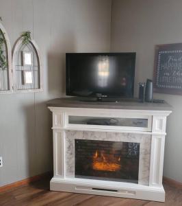 a living room with a fireplace with a tv on top at Cozy bungalow near Hanging Rock and Chateau Vie. 