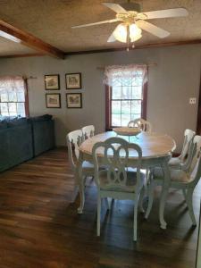 a dining room table with chairs and a ceiling fan at Cozy bungalow near Hanging Rock and Chateau Vie. 