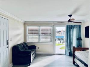 Cheerful home with one bedroom في كيب كورال: غرفة نوم مع أريكة ومروحة سقف