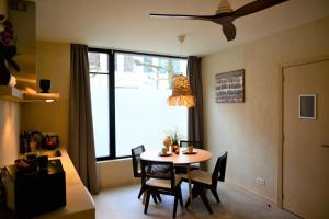 a dining room with a table and chairs and a window at Balinese Cityflat AC in Antwerp