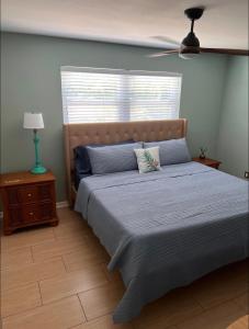 a bedroom with a bed and a window and a lamp at Cheerful home with one bedroom in Cape Coral