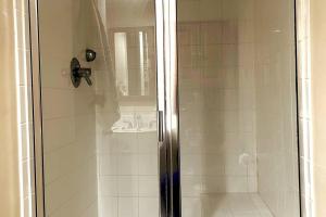 een douche met een glazen deur in de badkamer bij Tamarack Home Away from Home in Silver Spring