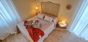 Casale Corte CerroにあるB&B Tra i Laghiのベッド1台(食料品のトレイ付)が備わる小さな客室です。