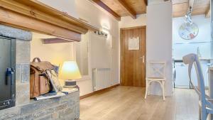 a living room with a stone fireplace and a lamp at Saplan Real Estate CARLAC in Les