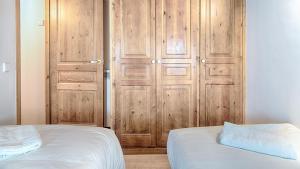 1 dormitorio con armario de madera, cama y puerta en Saplan Real Estate CARLAC, en Les