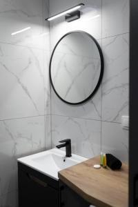 bagno con lavandino e specchio a parete di Apartament Rodzinny - Lamelowy Domek a Kudowa-Zdrój