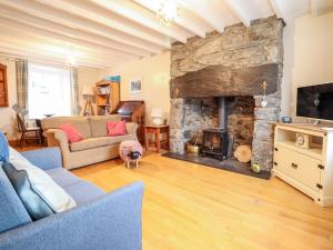 a living room with a large stone fireplace at Trigfa in Blaenau-Ffestiniog