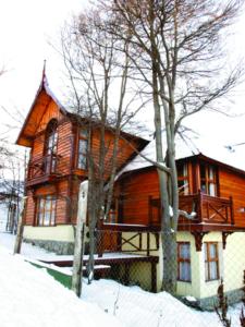 a large wooden house in the snow with trees at Cabañas Las Aguilas ADHERIDA PREVIAJE in Ushuaia