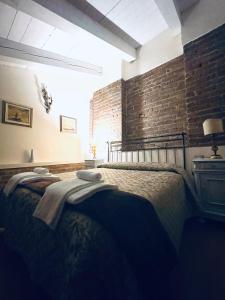 a bedroom with a bed with a brick wall at Relais Palazzo Paleologi Sec.XIV in Lu