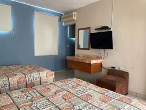 Habitación de hotel con 2 camas y TV de pantalla plana. en Hotel Santo Domingo Express, en Villahermosa