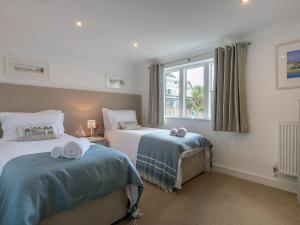 a bedroom with two beds and a window at Atlantis in St Ives +18 photos