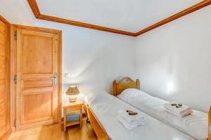 una camera con due letti e una porta in legno di Superb and calm flat with balcony in Megève - Welkeys a Megève