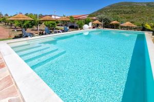 una piscina en un complejo con una montaña en el fondo en Residenza alla Collina & Romantic SPA en Porto Conte