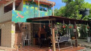 a house with a cat sitting in front of it at Selva Maria Tayrona's Hostel in Santa Marta