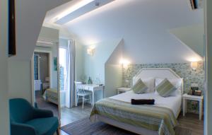 a bedroom with a bed and a chair and a table at OurMadeira - Babosas Village, gardénias and greenspaces in Funchal