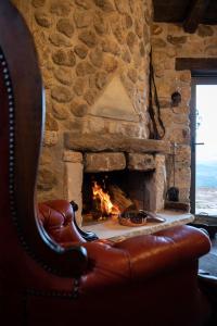 a stone fireplace with a couch in front of it at Silo Stone House 