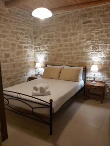 Un dormitorio con una cama con dos mesas y dos lámparas. en Vasiliki Villa, en Orthés