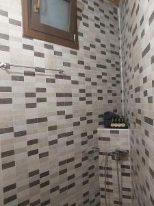Un baño con una pared de azulejos con ducha. en Vasiliki Villa, en Orthés 37 fotos más