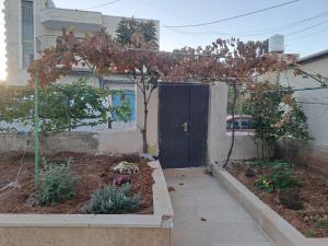 a garden with a black door in front of a house at The Lemon Homes in Bayt Sāḩūr