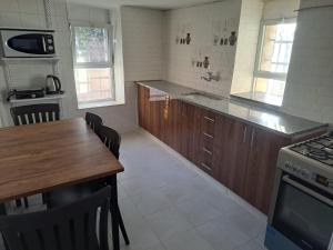 a kitchen with a wooden table and a counter top at The Lemon Homes in Bayt Sāḩūr