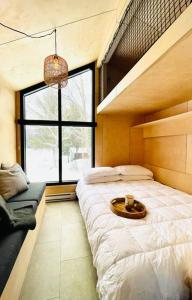 sypialnia z łóżkiem i dużym oknem w obiekcie Micro maison le Nordik w mieście Saint Zenon