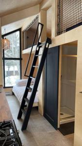 łóżko na podwyższeniu w pokoju z sypialnią w obiekcie Micro maison le Nordik w mieście Saint Zenon
