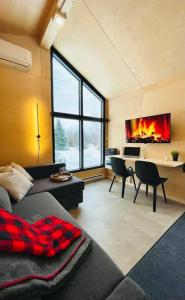 sala de estar con sofá y escritorio con chimenea en Micro maison le Nordik, en Saint Zenon