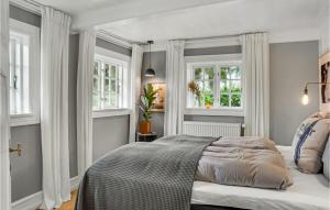 1 dormitorio con 1 cama y 2 ventanas en Beautiful Home In Stubbekbing With Kitchen, en Stubbekøbing