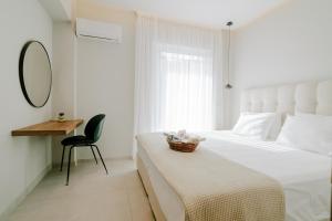 a bedroom with a bed and a chair and a mirror at Aelia Prime Experience 2 in Kos Town