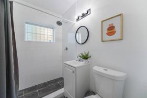 La salle de bains blanche est pourvue d'une douche et de toilettes. dans l'établissement Wonderful and calm studio in Miami, à Miami
