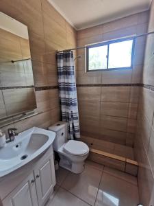 uma casa de banho com um WC, um lavatório e uma janela em Hospedaje Atitur em San Pedro de Atacama