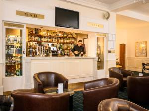 a man standing at a bar in a hotel room at Grant Arms Hotel in Grantown on Spey