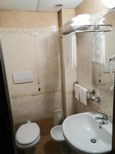 a bathroom with a white toilet and a sink at hotel de rossi in Bari