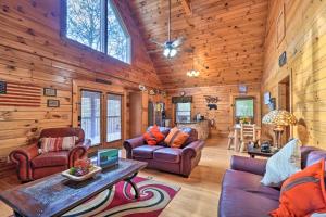a living room with wooden walls and furniture in a cabin at Inviting Sevierville Cabin with Deck and Hot Tub! in Sevierville
