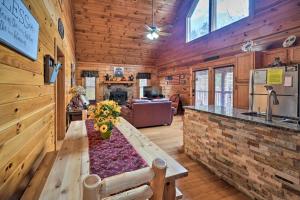 a kitchen and living room with a table in a log cabin at Inviting Sevierville Cabin with Deck and Hot Tub! in Sevierville
