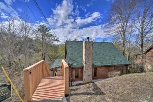 a log cabin with a staircase leading up to a house at Inviting Sevierville Cabin with Deck and Hot Tub! in Sevierville