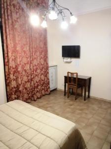 a bedroom with a bed and a desk and a television at hotel de rossi in Bari